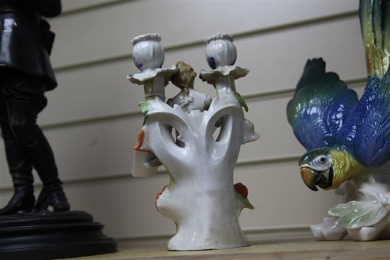 A Continental porcelain parrot and a two branch figural candelabrum